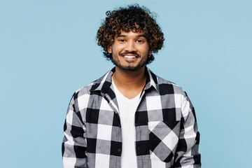 Young smiling happy cheerful satisfied cool Indian man he wears shirt white t-shirt casual clothes look camera isolated on plain pastel light blue cyan background studio portrait. Lifestyle concept