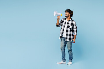 Full body young Indian man he wears shirt white t-shirt casual clothes hold in hand megaphone scream announces discounts sale Hurry up isolated on plain pastel blue cyan background. Lifestyle concept.