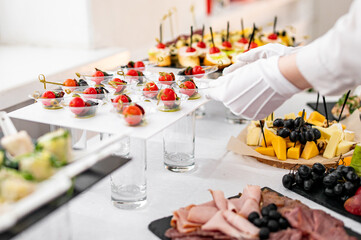 woman hands of a waiter prepare food for a buffet table in a restaurant