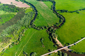 View from a high altitude of a landscape with a river and an oxbow surrounded by green fields