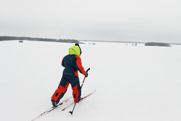 Boys in overalls goes skiing across the field