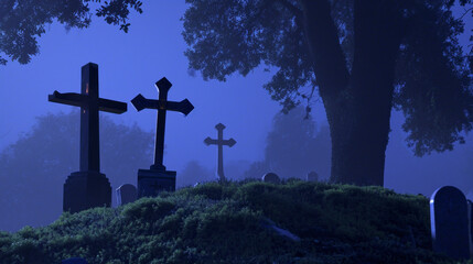 A group of crosses sit on top of a lush green hillside, creating a foggy, dark graveyard landscape at night.