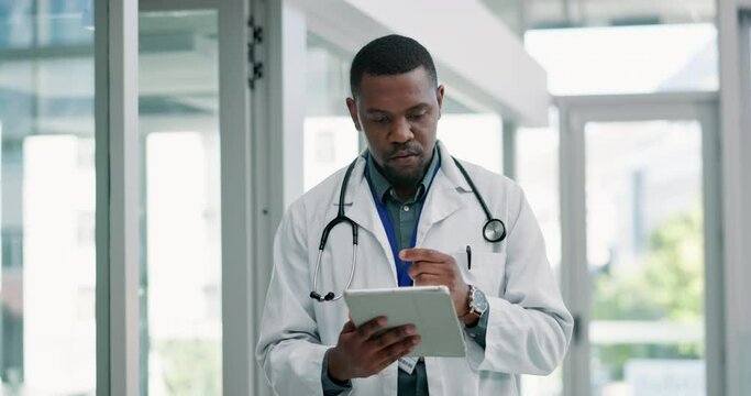 Doctor, typing on tablet and planning with hospital or clinic research, online planning and telehealth test or solution. African worker walking in a clinic with digital technology for medical report