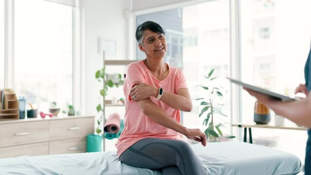 Old woman, person and physio consultation talking on bench for arm pain problem, muscle or elderly age. Patient, helper and tablet in clinic for rehabilitation service or mobility, advice or support