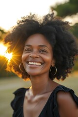 Middle-aged African woman smiling brightly outdoors.