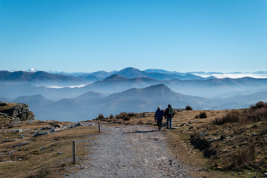 Em meio ao frio g&eacute;lido: Um casal turistas de m&atilde;os dadas no pico da montanha de La Rhune, contemplando a vastid&atilde;o das montanhas