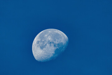 Waning moon in daylight and blue sky