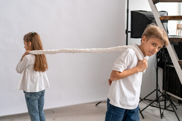 Capturing candid moment, this image showcases young boy and girl playfully engaged in tug of war...