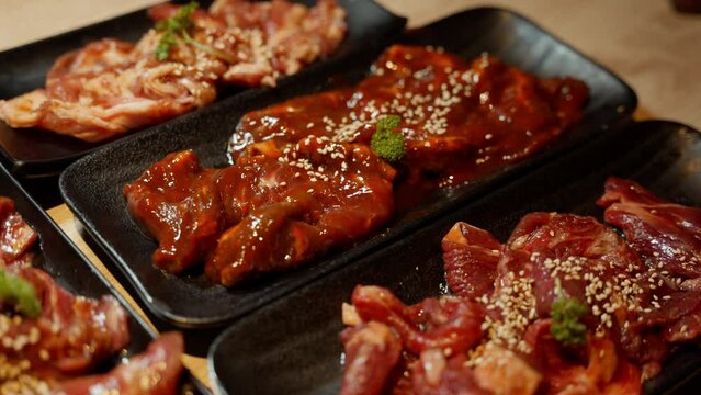 An exquisite tableau awaits the grill's embrace as raw beef, impeccably arranged on a yakiniku plate, beckons culinary transformation. The anticipation of searing flavors and succulent textures.