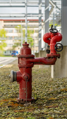 Fototapeta na wymiar A red fire hydrant at an industrial plant.