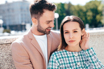 Obraz premium Beautiful fashion woman and her handsome elegant boyfriend in beige suit. Sexy brunette model in summer clothes. Fashionable smiling couple posing in street Europe. Brutal man and female outdoors