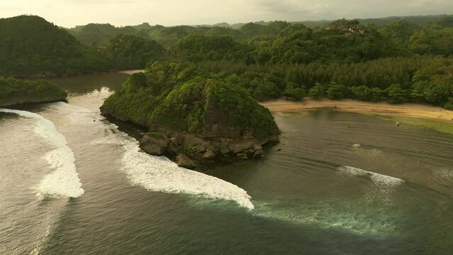 Teluk Asmara Beach in Malang, East Java, Indonesia: Sunset unveils a mesmerizing blend of beautiful reefs, gentle waves, and pristine white sand, creating a perfect coastal haven.