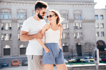 Smiling beautiful woman and her handsome boyfriend. Woman in casual summer clothes. Happy cheerful family. Female having fun. Couple posing in street at sunny day. Having tender moments. In sunglasses