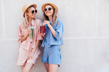 Two young beautiful smiling hipster female in trendy summer clothes. Carefree women posing...