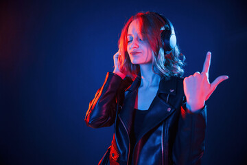 With headphones. Cool young woman portrait in neon colors