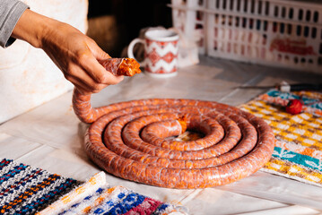 Crop woman preparing delicious homemade chorizo in kitchen - obrazy, fototapety, plakaty