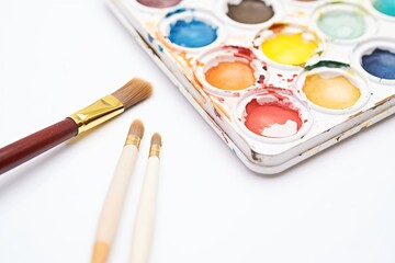 Naklejka premium close-up of watercolors palette and brush bristles on white background
