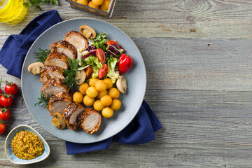 Pork tenderloin, served with mushrooms and peppers.