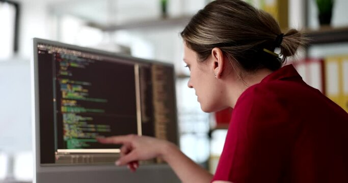 IT developer woman studying programming code on computer screen in office. Fixing bugs in programs and improving code