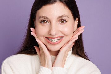 portrait of a girl with braces, woman happy with braces shows ok sign