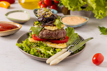 Beef burger without a bun, served on a plate with halloumi cheese.