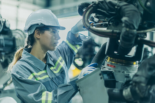 Engineer working machine assembly in advance technology robotic factory industry, Service maintenance robot arm cable part