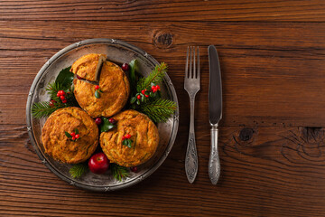 Small, baked patties in Christmas retro styling. Top view. Natural wooden background.