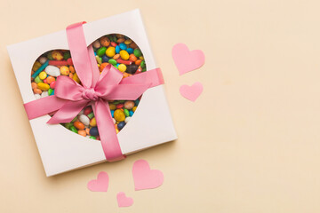 Valentine day composition: sweet candy, with gift boxes with bow and red felt hearts, photo...