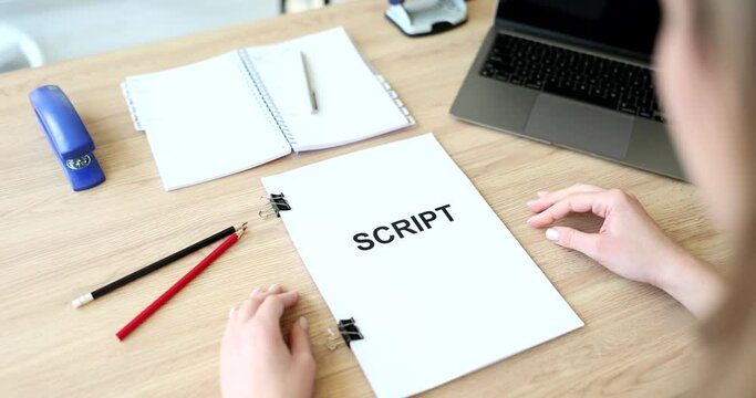 Woman hands hold and read script over table closeup. Director script that comprehensively decides further shooting and work of actors