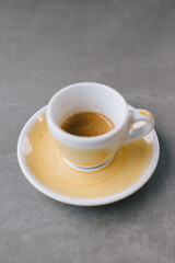 Close up of a cup of espresso or dopio on a gray stone background.