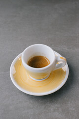 Close up of a cup of espresso or dopio on a gray stone background.