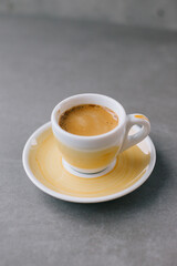 Close up of a cup of espresso or dopio on a gray stone background.
