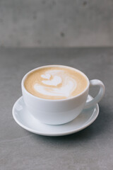 Fototapeta premium Close up of a cup of latte on a gray stone background.
