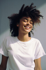 Young happy smiling African American woman model wearing tshirt standing on color background. Face skin hair care cosmetics makeup, fashion ads. Beauty portrait. White t-shirt mock up template .