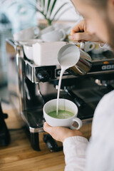 Fototapeta na wymiar Barista prepares tasty and healthy matcha latte tea..