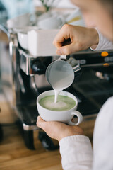Barista prepares tasty and healthy matcha latte tea..