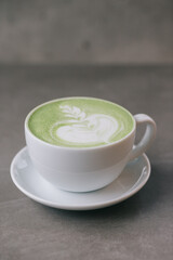 A cup of matcha on a gray stone background. Close up.