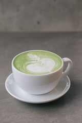A cup of matcha on a gray stone background. Close up.