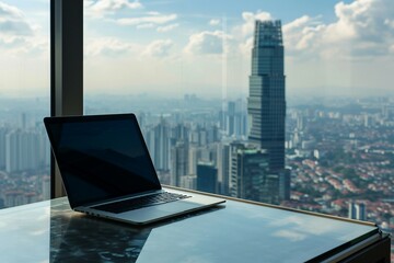 a laptop on a table with a city view in the background