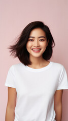Fototapeta premium Young happy smiling Asian woman model wearing tshirt looking at camera on color background. Face skin hair care korean cosmetic and makeup, fashion ads. Beauty portrait. White t-shirt mock up template