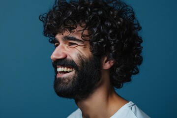 a man with curly hair and beard smiling