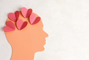 A human head filled with hearts on a light background. The concept of a man in love.