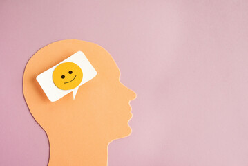 Head with happy thoughts. A symbol of a human head and a bubble with a positive face inside.