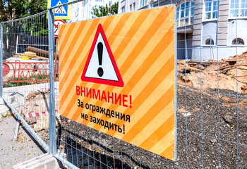 Warning sign at the construction site. Text in russian: Attention! Do not go beyond the fences! - 725440688
