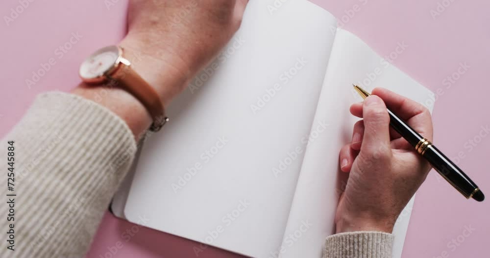 Poster close up of hand writing with pen on book with copy space on white background in slow motion