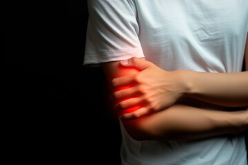 Person suffering from elbow pain, health concept of joint injury or arthritis. Problem area highlighted by red aura.
