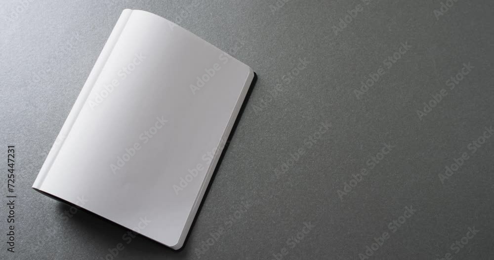 Poster close up of open blank book with copy space on gray background in slow motion