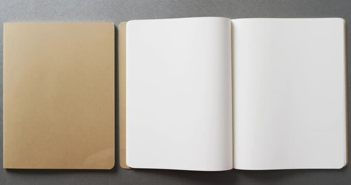 Close up of open blank and book brown notebook with copy space on gray background in slow motion