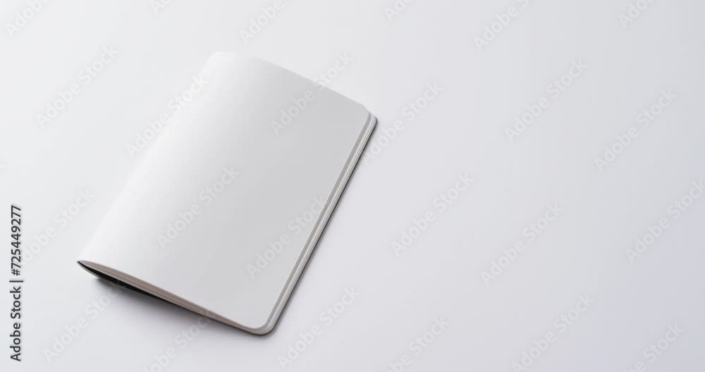 Poster close up of open blank book with copy space on white background in slow motion