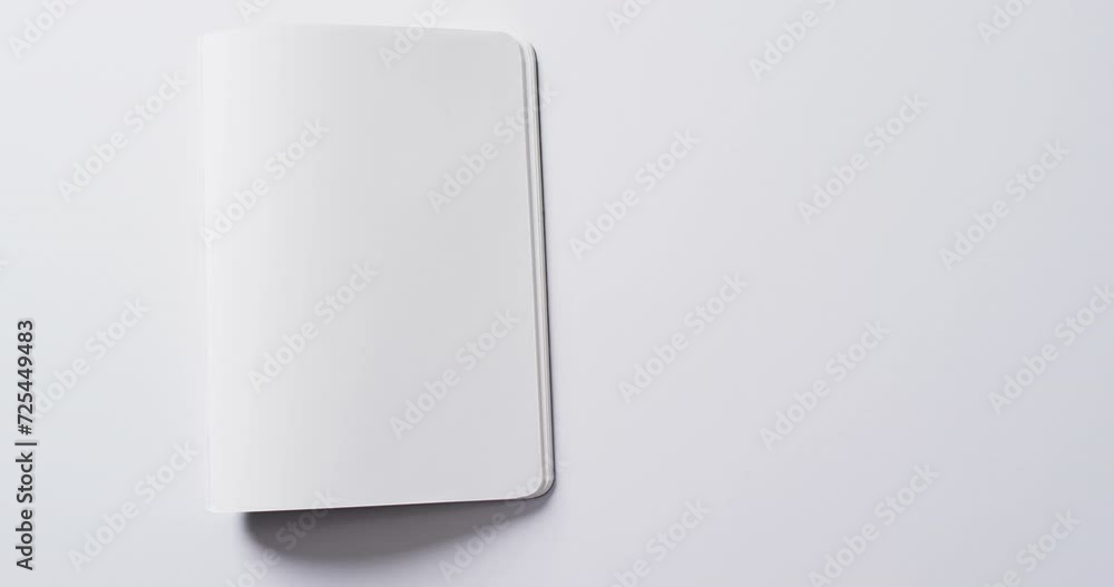 Poster close up of open blank book with copy space on white background in slow motion